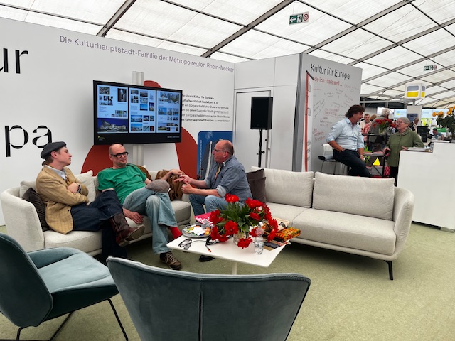 Gesprächssituation am Stand mit Präsentation der Heidelberger Schlossgespräche